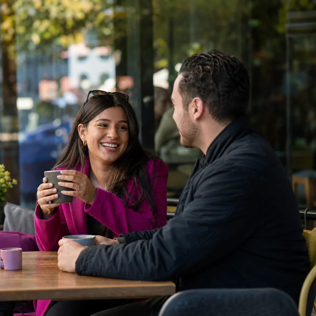 Two adults meeting at a busy café near Watford town centre